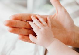 cute-newborn-baby-holding-mothers-hand-while-PJRFCSY
