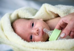 newborn-baby-boy-with-plastik-bottle-closeup